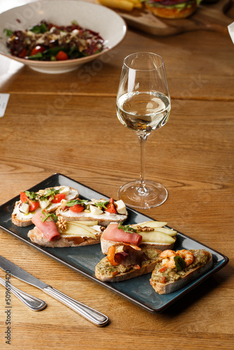 Obraz na płótnie Bruschettas with vegetables. Start dishes with cherry tomatoes, avocado, cream cheese and shrimps. Food composition, tasty italian meal w salonie
