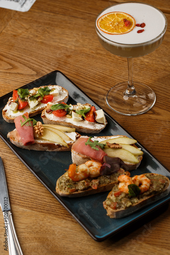 Obraz na płótnie Bruschettas with vegetables. Start dishes with cherry tomatoes, avocado, cream cheese and shrimps. Food composition, tasty italian meal w salonie