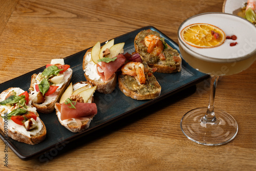Obraz na płótnie Bruschettas with vegetables. Start dishes with cherry tomatoes, avocado, cream cheese and shrimps. Food composition, tasty italian meal w salonie