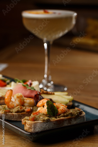Obraz na płótnie Bruschettas with vegetables. Start dishes with cherry tomatoes, avocado, cream cheese and shrimps. Food composition, tasty italian meal w salonie