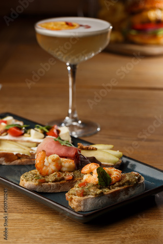 Obraz na płótnie Bruschettas with vegetables. Start dishes with cherry tomatoes, avocado, cream cheese and shrimps. Food composition, tasty italian meal w salonie