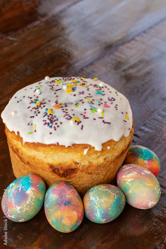 Easter cake with multicolored Easter eggs. Bright packaging. Preparations for Easter. Festive cakes with white glaze Easter cake with multicolored Easter eggs. Bright packaging. Preparations for Easter. Festive cakes with white glaze