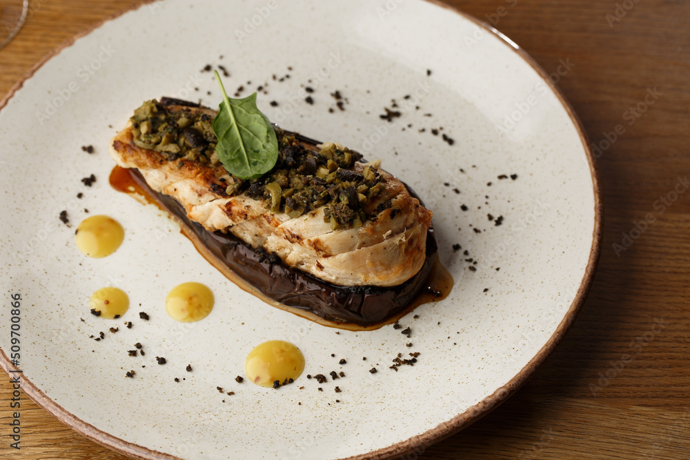 Baked eggplant stuffed with grilled chicken, tomatoes and spices on white plate. Traditional dish Karniyarik of turkish cuisine. View from above