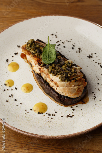 Baked eggplant stuffed with grilled chicken, tomatoes and spices on white plate. Traditional dish Karniyarik of turkish cuisine. View from above
