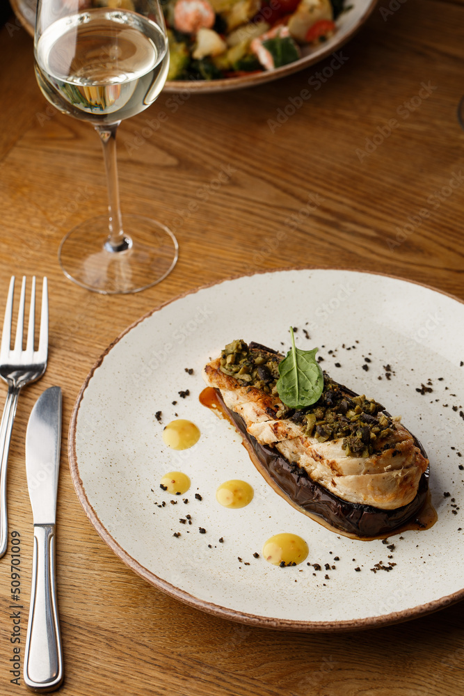 Baked eggplant stuffed with grilled chicken, tomatoes and spices on white plate. Traditional dish Karniyarik of turkish cuisine. View from above
