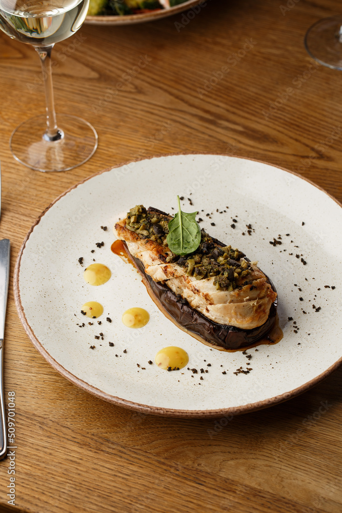 Baked eggplant stuffed with grilled chicken, tomatoes and spices on white plate. Traditional dish Karniyarik of turkish cuisine. View from above