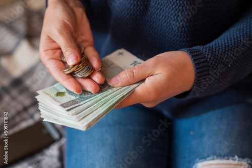 the girl holds in her hands banknotes money polish zlotys and pennies coins salary for payment photo