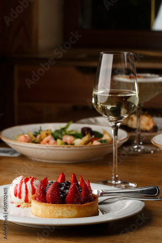 Obraz na płótnie Berry tartlets with curd cream on a wooden background. Summer fruit baking. Tartlets with raspberries, blueberries and red currants. Served with ice cream. w salonie