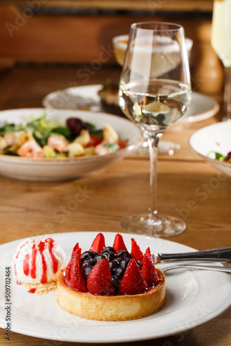 Obraz na płótnie Berry tartlets with curd cream on a wooden background. Summer fruit baking. Tartlets with raspberries, blueberries and red currants. Served with ice cream. w salonie