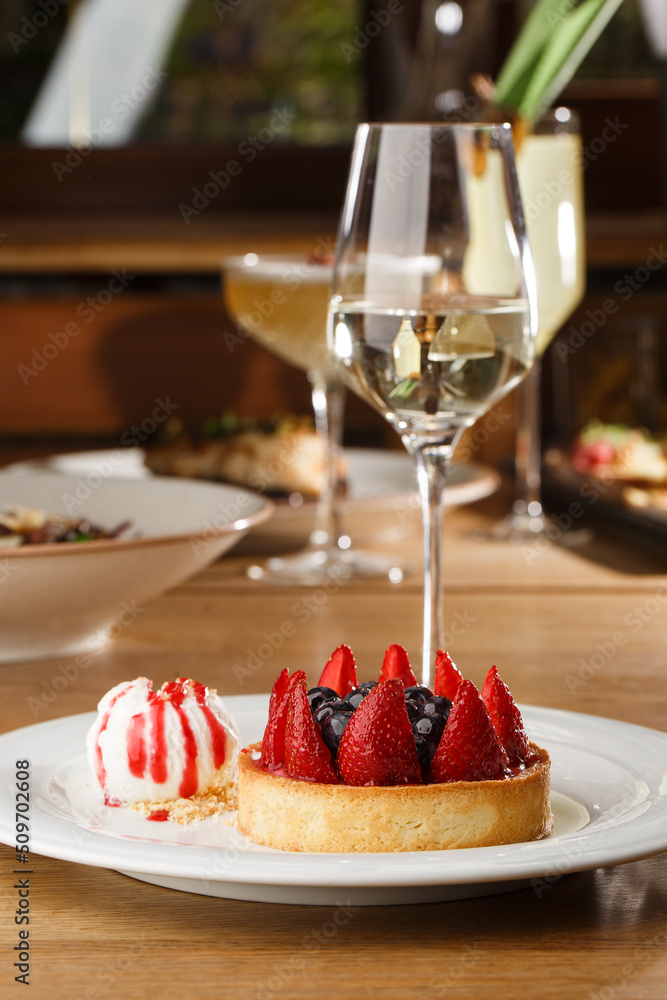 Berry tartlets with curd cream on a wooden background. Summer fruit baking. Tartlets with raspberries, blueberries and red currants. Served with ice cream.