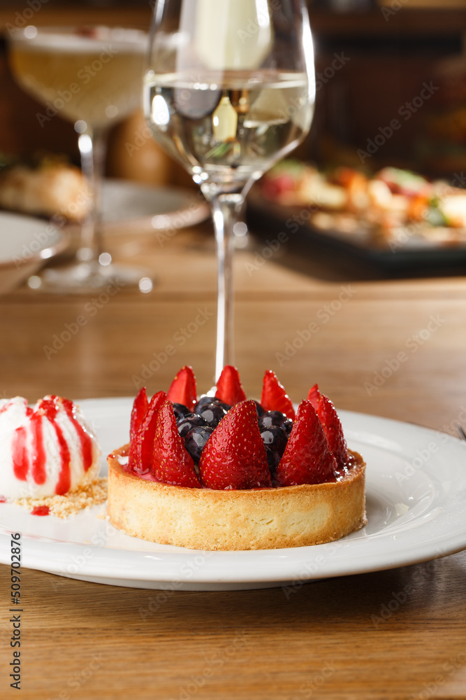 Berry tartlets with curd cream on a wooden background. Summer fruit baking. Tartlets with raspberries, blueberries and red currants. Served with ice cream.