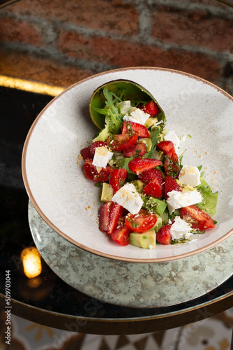 Obraz na płótnie Tasty and healthy salad with arugula, brie cheese, avocado, cherry tomatoes and strawberry. Top view. The flat lay. Banner w salonie