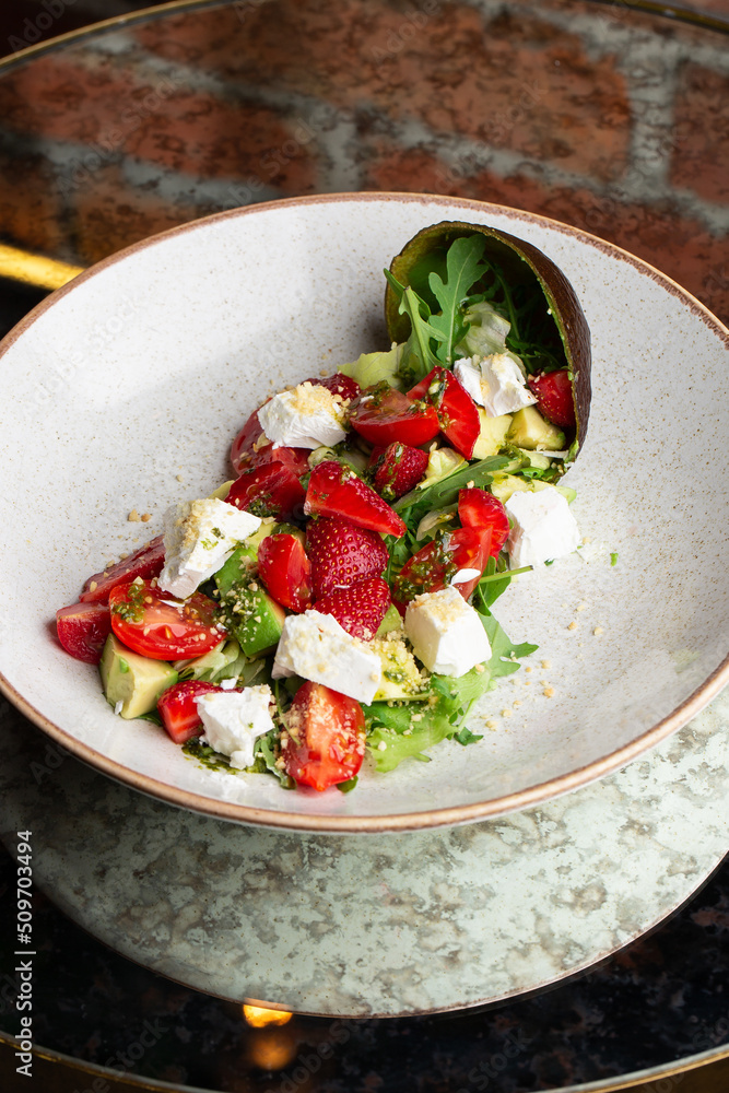Tasty and healthy salad with arugula, brie cheese, avocado, cherry tomatoes and strawberry. Top view. The flat lay. Banner