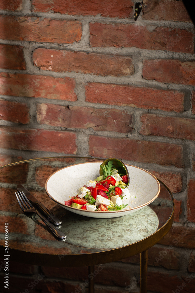 Tasty and healthy salad with arugula, brie cheese, avocado, cherry tomatoes and strawberry. Top view. The flat lay. Banner