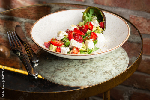 Obraz na płótnie Tasty and healthy salad with arugula, brie cheese, avocado, cherry tomatoes and strawberry. Top view. The flat lay. Banner w salonie