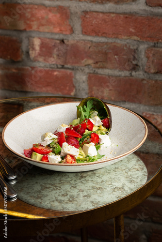 Obraz na płótnie Tasty and healthy salad with arugula, brie cheese, avocado, cherry tomatoes and strawberry. Top view. The flat lay. Banner w salonie