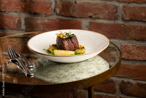 Obraz na płótnie Grilled meat fillet steak medallion with green sauce, served with pear or apple. On dark background w salonie