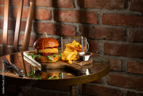 Obraz na płótnie Big cheeseburger with french fries. Hamburger with beef patty onion, tomato, lettuce pickles, melted cheddar, mustards, tomato jam, mayo w salonie