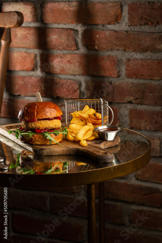 Obraz na płótnie Big cheeseburger with french fries. Hamburger with beef patty onion, tomato, lettuce pickles, melted cheddar, mustards, tomato jam, mayo w salonie