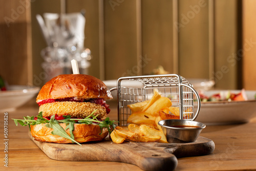 Obraz na płótnie Big cheeseburger with french fries. Hamburger with beef patty onion, tomato, lettuce pickles, melted cheddar, mustards, tomato jam, mayo w salonie
