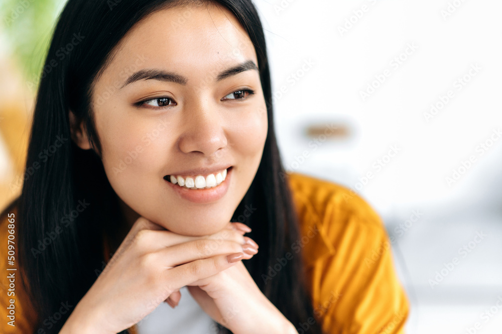 Close-up photo of a lovely positive brunette modern brown-eyed girl of asian nationality, wearing casual clothes, looking to the side, indoors, smiling friendly, dreaming, thinking Close-up photo of a lovely positive brunette modern brown-eyed girl of asian nationality, wearing casual clothes, looking to the side, indoors, smiling friendly, dreaming, thinking