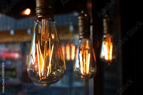Edison light bulb lamps hanging near cafe window close-up