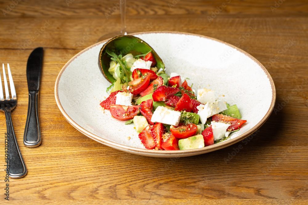 Tasty and healthy salad with arugula, brie cheese, avocado, cherry tomatoes and strawberry. Top view. The flat lay. Banner