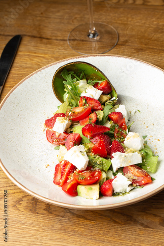 Obraz na płótnie Tasty and healthy salad with arugula, brie cheese, avocado, cherry tomatoes and strawberry. Top view. The flat lay. Banner w salonie