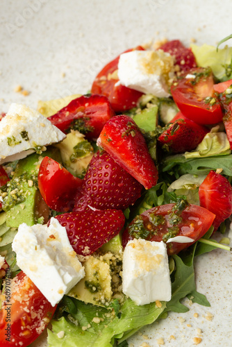 Obraz na płótnie Tasty and healthy salad with arugula, brie cheese, avocado, cherry tomatoes and strawberry. Top view. The flat lay. Banner w salonie
