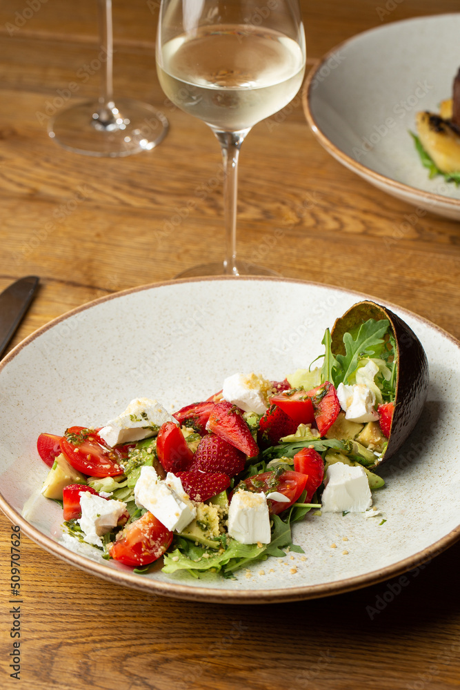 Tasty and healthy salad with arugula, brie cheese, avocado, cherry tomatoes and strawberry. Top view. The flat lay. Banner