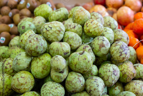 Many of fresh juicy cherimoya, put up for sale on the counter. Close-up image