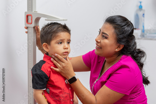 Fotografía close up of a female pediatrician doctor measuring a child's height with a pedes