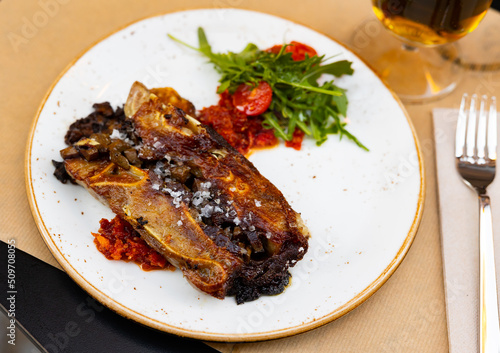 Appetizing meat dish Terrine of pork ears and kidneys with red pesto sauce, served with cherry tomatoes and fresh herbs