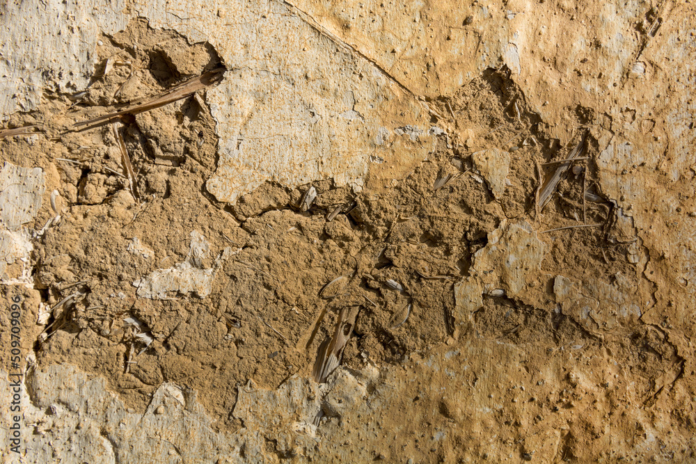A dirty wall of mud and straw on a dilapidated country house. Close up and copy space for text or design A dirty wall of mud and straw on a dilapidated country house. Close up and copy space for text or design
