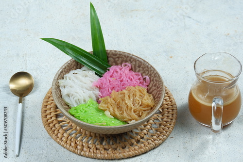 Kue Putu Mayang or petulo is traditional Indonesian snack made from rice flour strands curled up into a ball, served with coconut milk and palm sugar photo