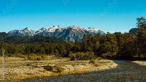 Obraz na płótnie River in a beautiful meadow with snowy mountains in the background. Los Alerces National Park w salonie