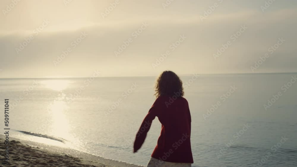 Happy girl turning around on beach at sunrise. Excited woman having fun Happy girl turning around on beach at sunrise. Excited woman having fun