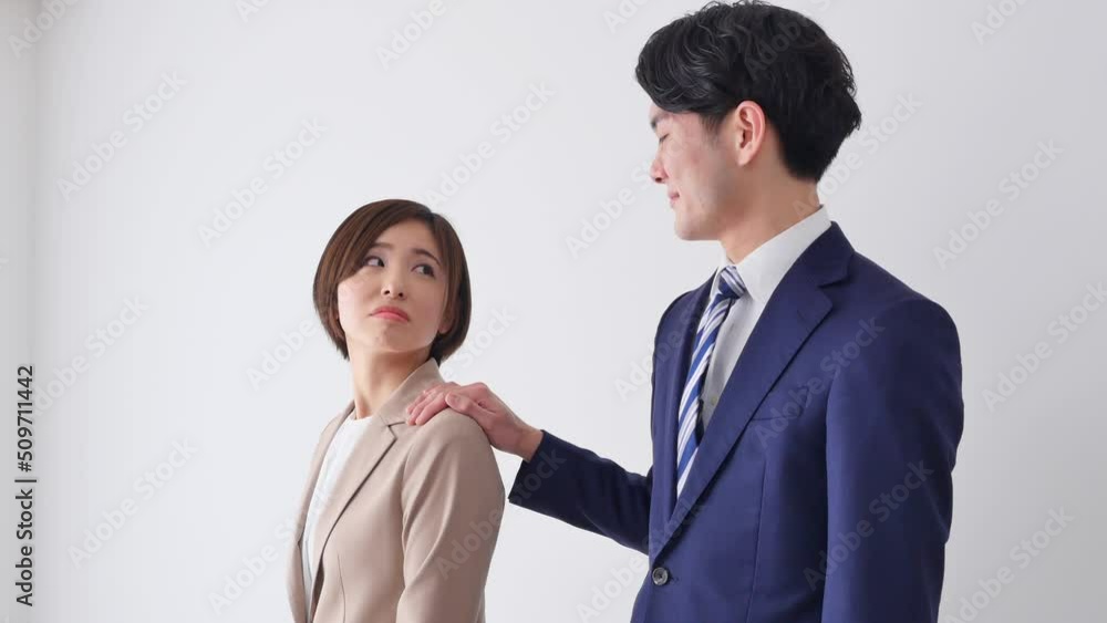 白バックでビジネスウーマンの肩を掴むビジネスマン