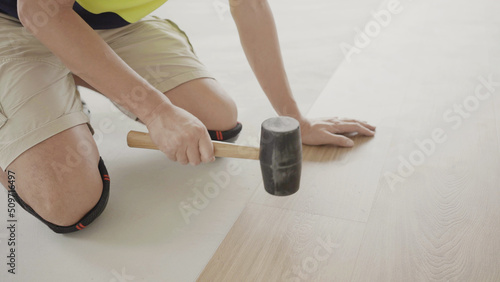 Man installing new timber laminated wooden floor, home improvement, house renovation project concept