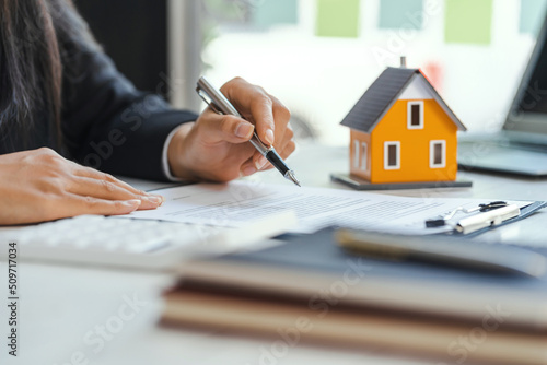 Photos Real estate agent working sign agreement document contract for home loan insurance approving purchases for client with house model