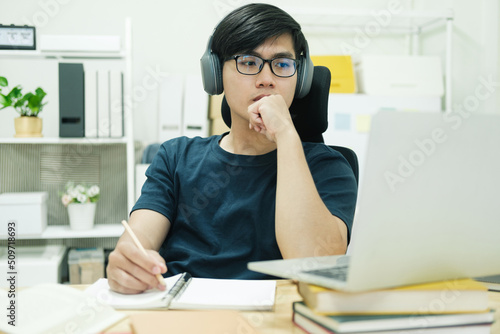 Young man study in front of the laptop computer at home