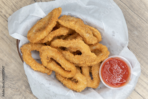 Overhead view of delicious basket of fried calamari rings for an appetizer of a seafood meal