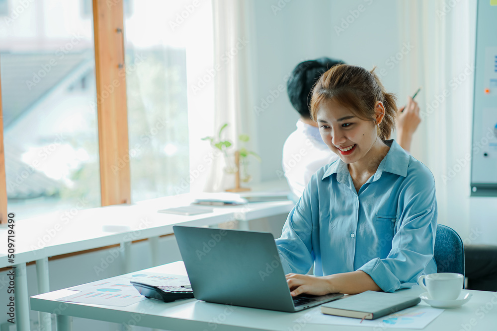 The concept of working together for young handsome and beautiful youngsters working on financial accounting and graphing, analyzing, and calculating documents with the laptop on a desk in the office. The concept of working together for young handsome and beautiful youngsters working on financial accounting and graphing, analyzing, and calculating documents with the laptop on a desk in the office.