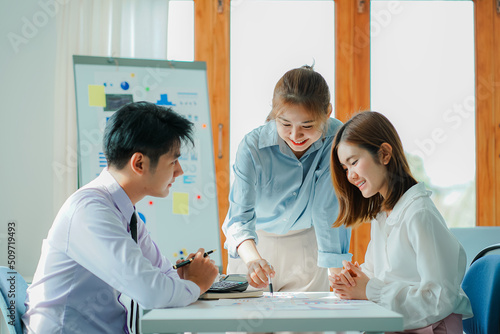 Canvas Print Asian and Caucasian corporate executives discuss business in a conference room of three young businessmen and women discussing tech startups about product roadmaps, and collaboration ideas