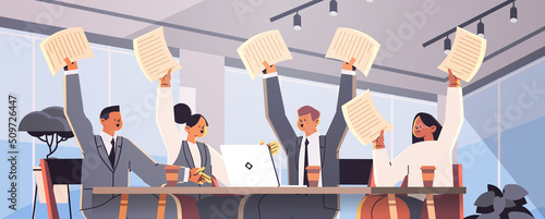 excited business people holding paper documents businesspeople sitting at office desk hold hands arms up
