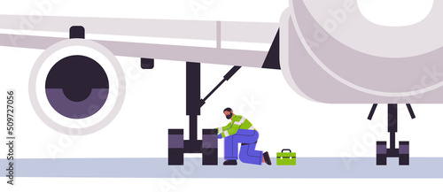 aviation supervisor worker mechanic in signal vest engineer repairing aircraft landing gear wheel professional airport staff