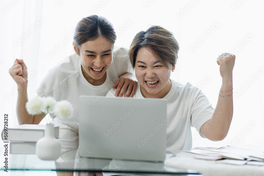 Happy lgbt gay couple of Asian women having fun using a computer laptop at home - LGBT lesbian relationship, Asian LGBTQ female lesbian concept. Happy lgbt gay couple of Asian women having fun using a computer laptop at home - LGBT lesbian relationship, Asian LGBTQ female lesbian concept.