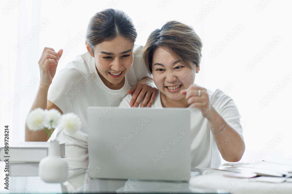 Happy lgbt gay couple of Asian women having fun using a computer laptop at home - LGBT lesbian relationship, Asian LGBTQ female lesbian concept. Happy lgbt gay couple of Asian women having fun using a computer laptop at home - LGBT lesbian relationship, Asian LGBTQ female lesbian concept.