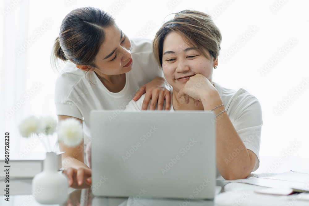Happy lgbt gay couple of Asian women having fun using a computer laptop at home - LGBT lesbian relationship, Asian LGBTQ female lesbian concept. Happy lgbt gay couple of Asian women having fun using a computer laptop at home - LGBT lesbian relationship, Asian LGBTQ female lesbian concept.