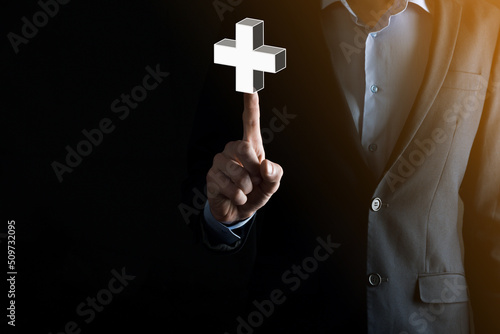 Businessman hold 3D plus icon, man hold in hand offer positive thing such as profit, benefits, development, CSR represented by plus sign.The hand shows the plus sign